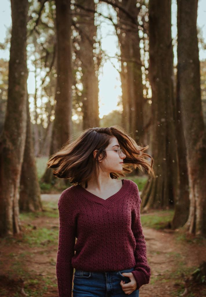 Woman enjoy green space, walking through the forest